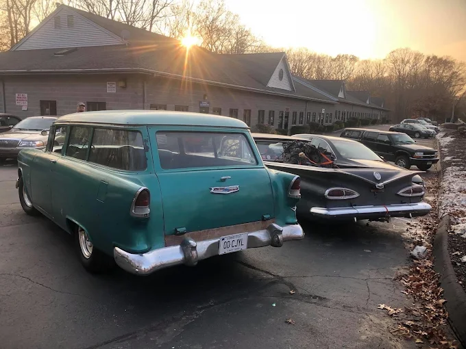 Classic wagon and Chevy parked outside the Clinton, CT shop at sunrise